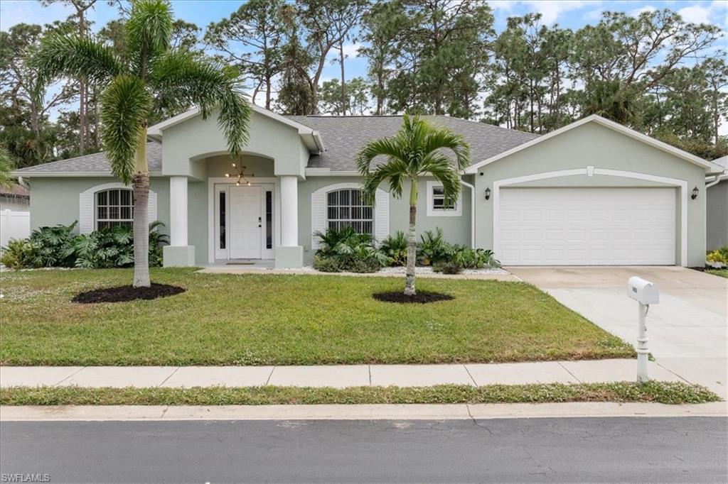 Ranch-style house featuring a garage and a front yard