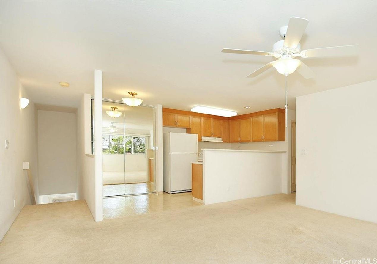 a view of a room with a ceiling fan and entryway