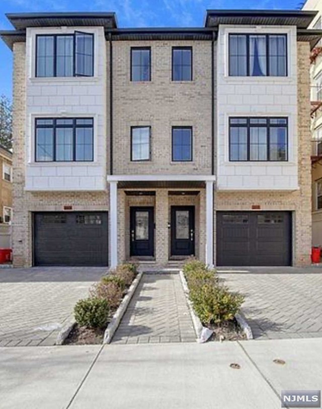 a front view of a house with yard and parking space