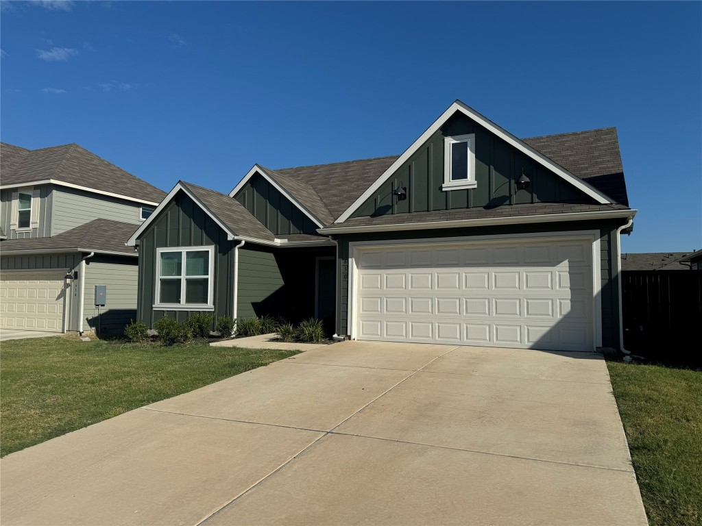 a front view of a house with yard and garage