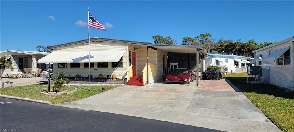 Manufactured / mobile home featuring a carport and a front lawn