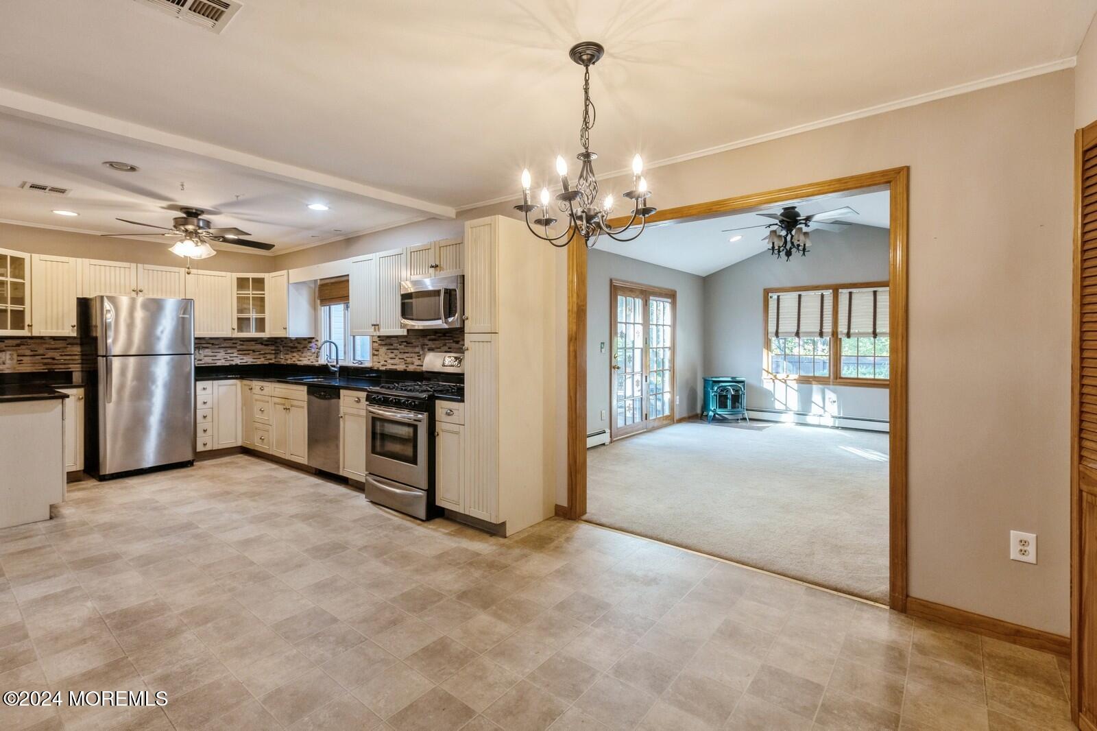 a view of a kitchen with stainless steel appliances granite countertop a refrigerator and a sink