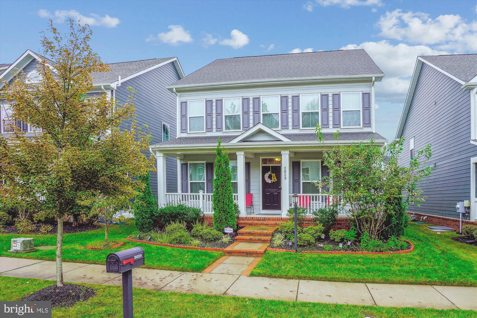 a front view of a house with a yard and potted plants