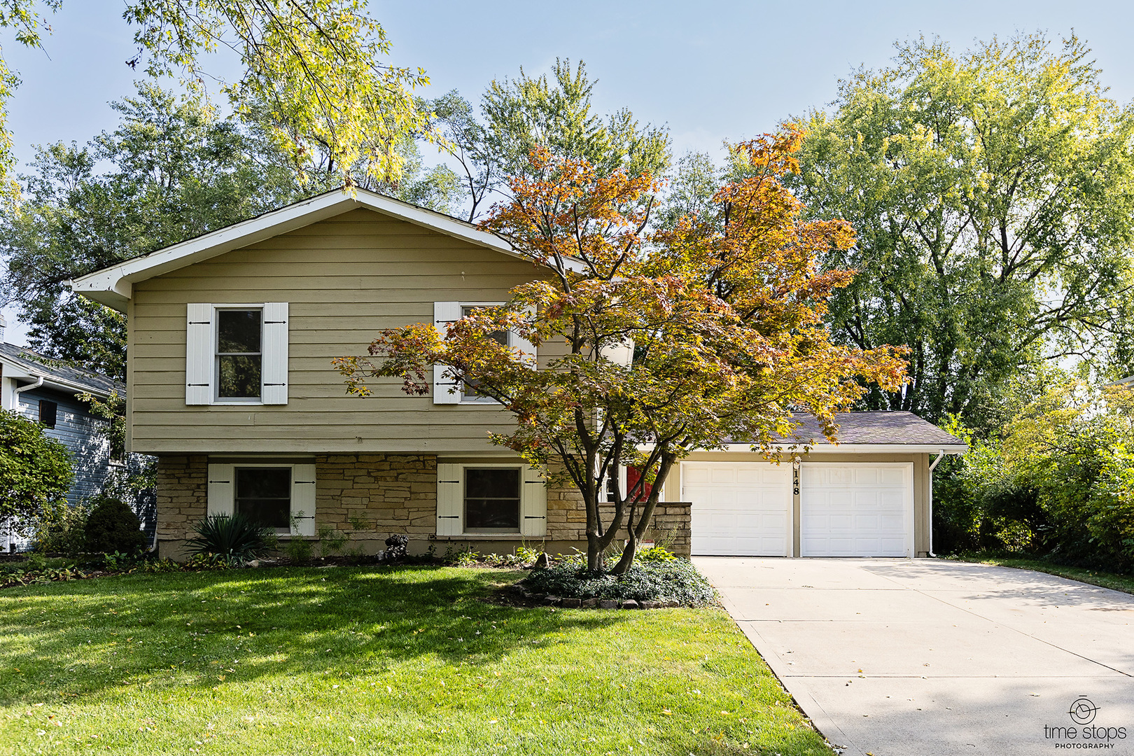 a front view of a house with a yard and trees