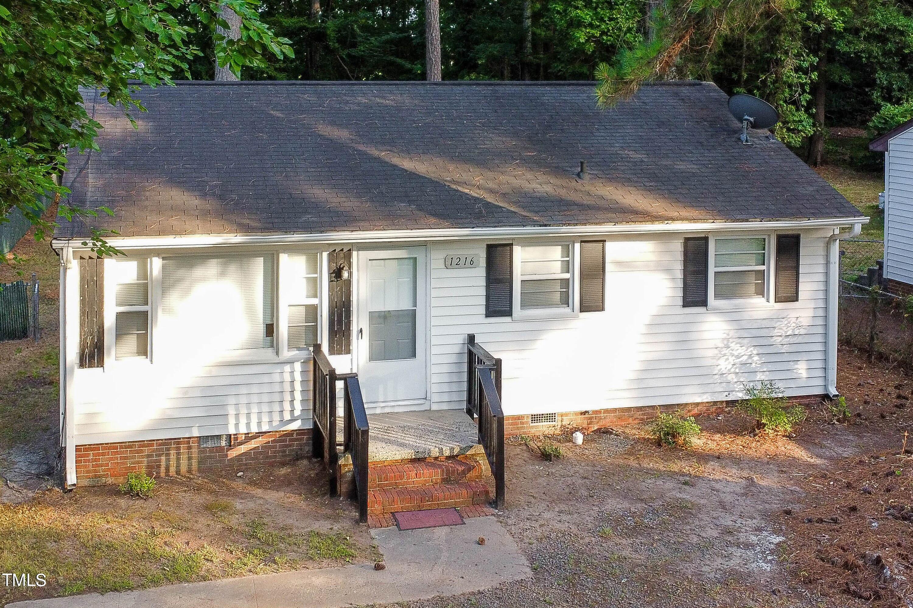 a view of a house with backyard and sitting area