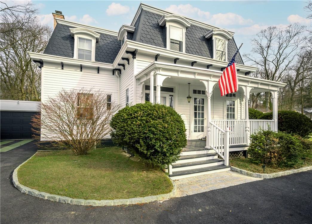 a view of a white house with large windows and a yard