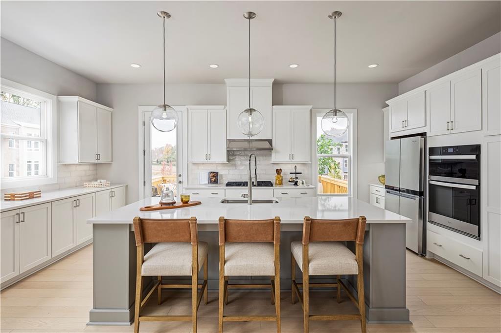 a kitchen with kitchen island white cabinets and stainless steel appliances