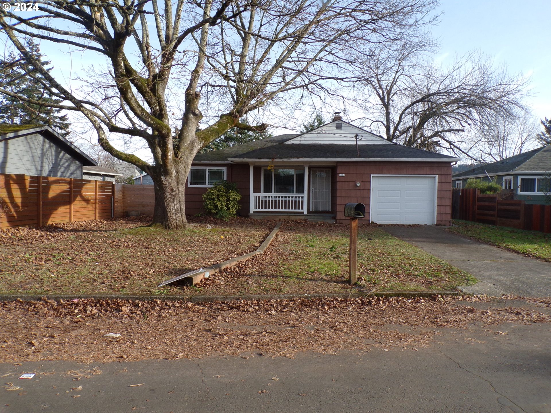 a view of a house with a yard and large tree