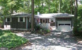 a view of a house with a yard and potted plants