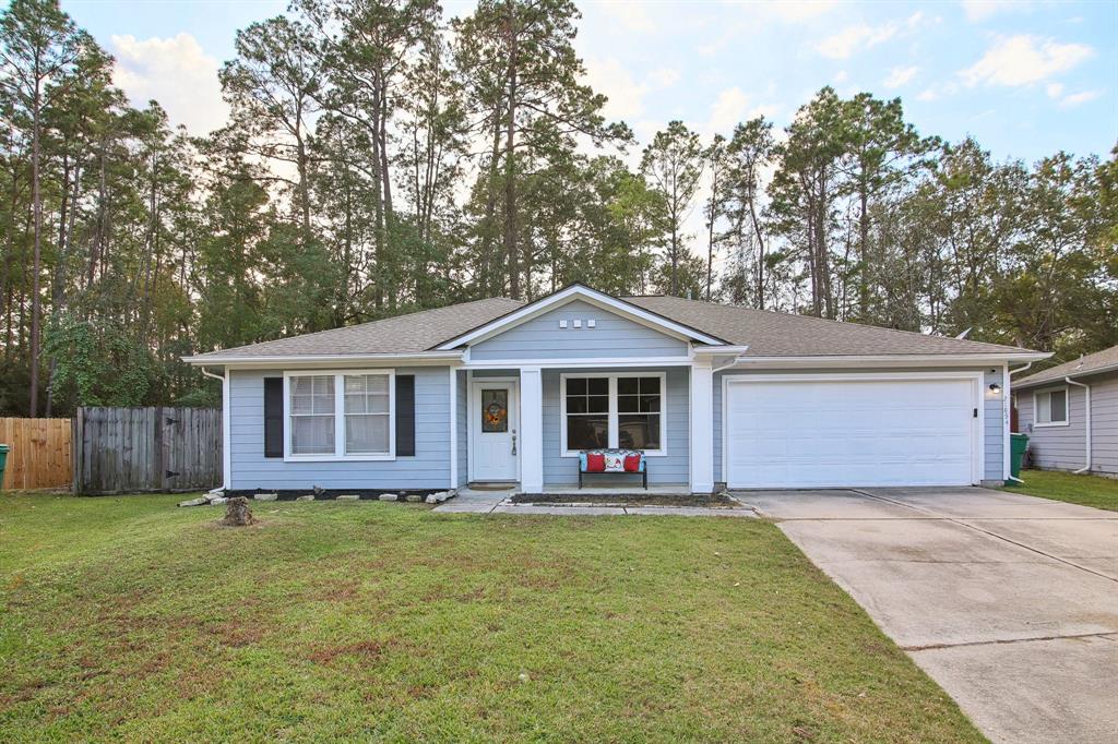 a front view of house with yard and trees in the background