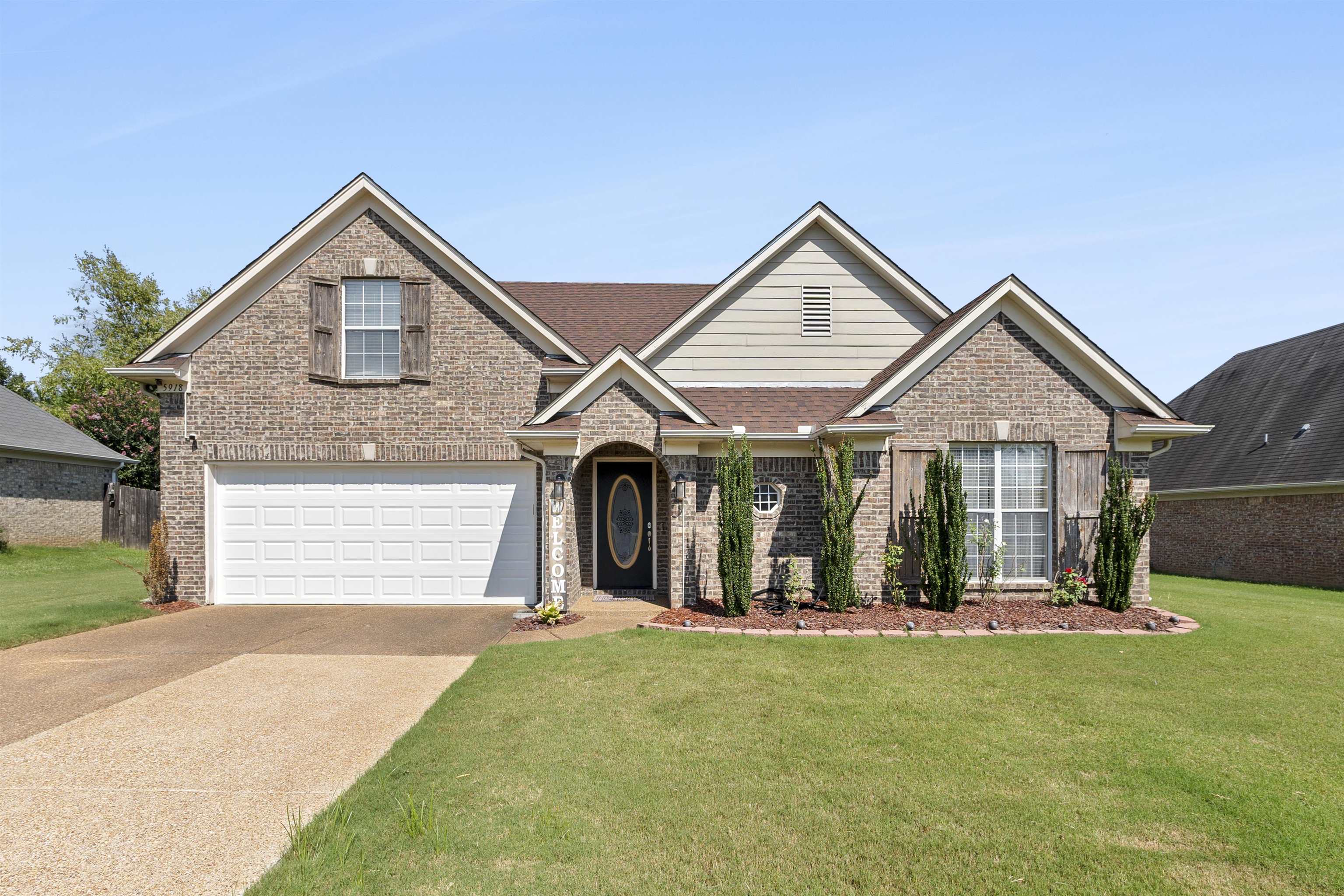 a front view of a house with a yard and garage