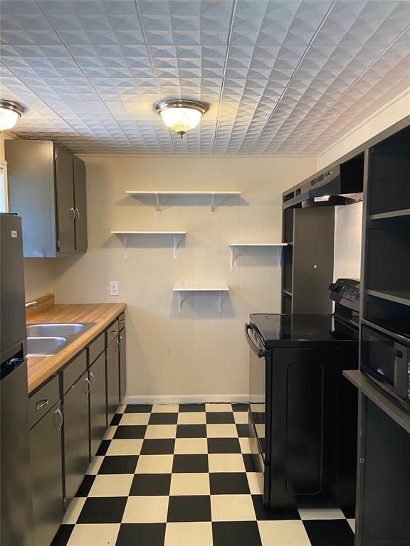 a kitchen with a checkered floor and white cabinets