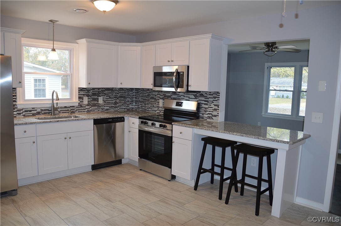 Kitchen with a wealth of natural light, white cabi