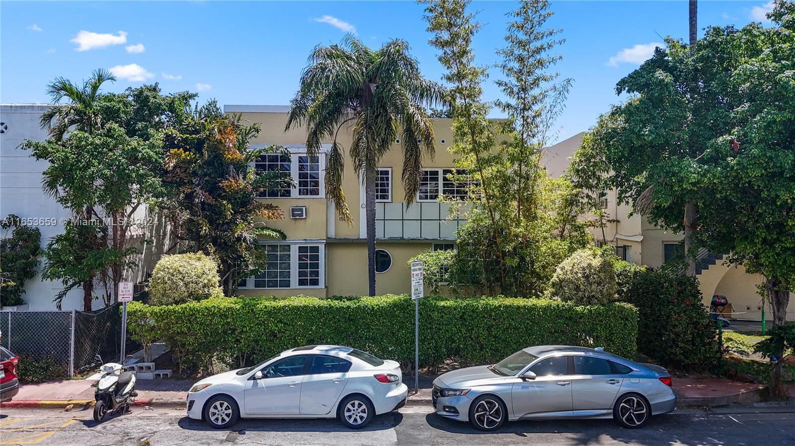 a car parked in front of a house and a cars parked on the road