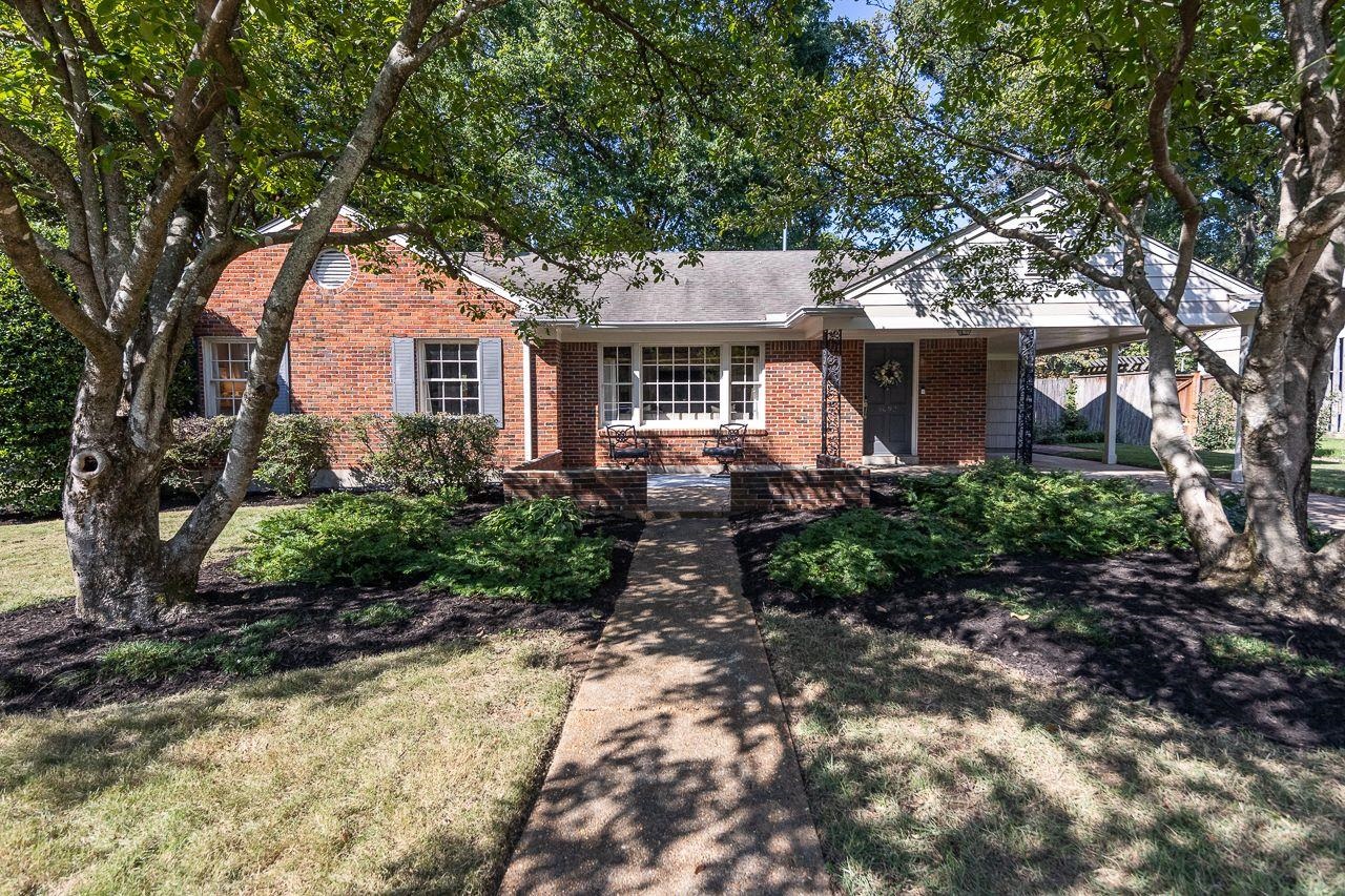 a front view of house with yard and trees around