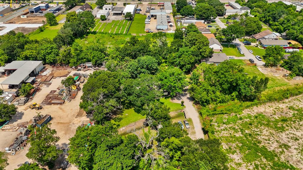 an aerial view of residential houses with outdoor space and trees