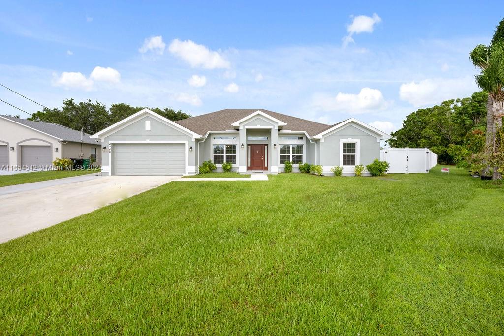 a front view of a house with a yard and trees