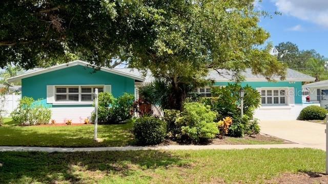 a front view of a house with a yard and potted plants