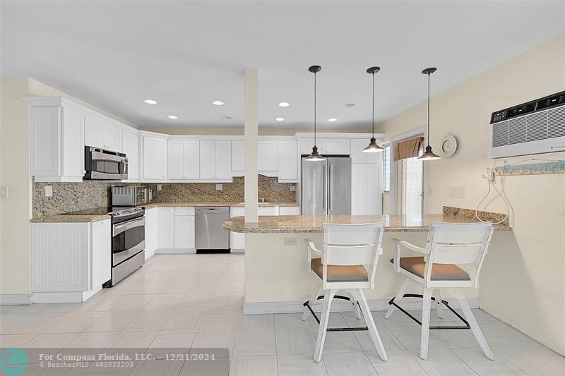 Your 1st Floor Unit Features an Updated and Open Kitchen with Stainless Steel Appliances, Granite Countertops and a Snack Bar with Extra Cabinet Storage. This in one of the few Open Kitchens in the building which lends itself to Great Entertaining. Your Kitchen has POOLSIDE VIEWS!