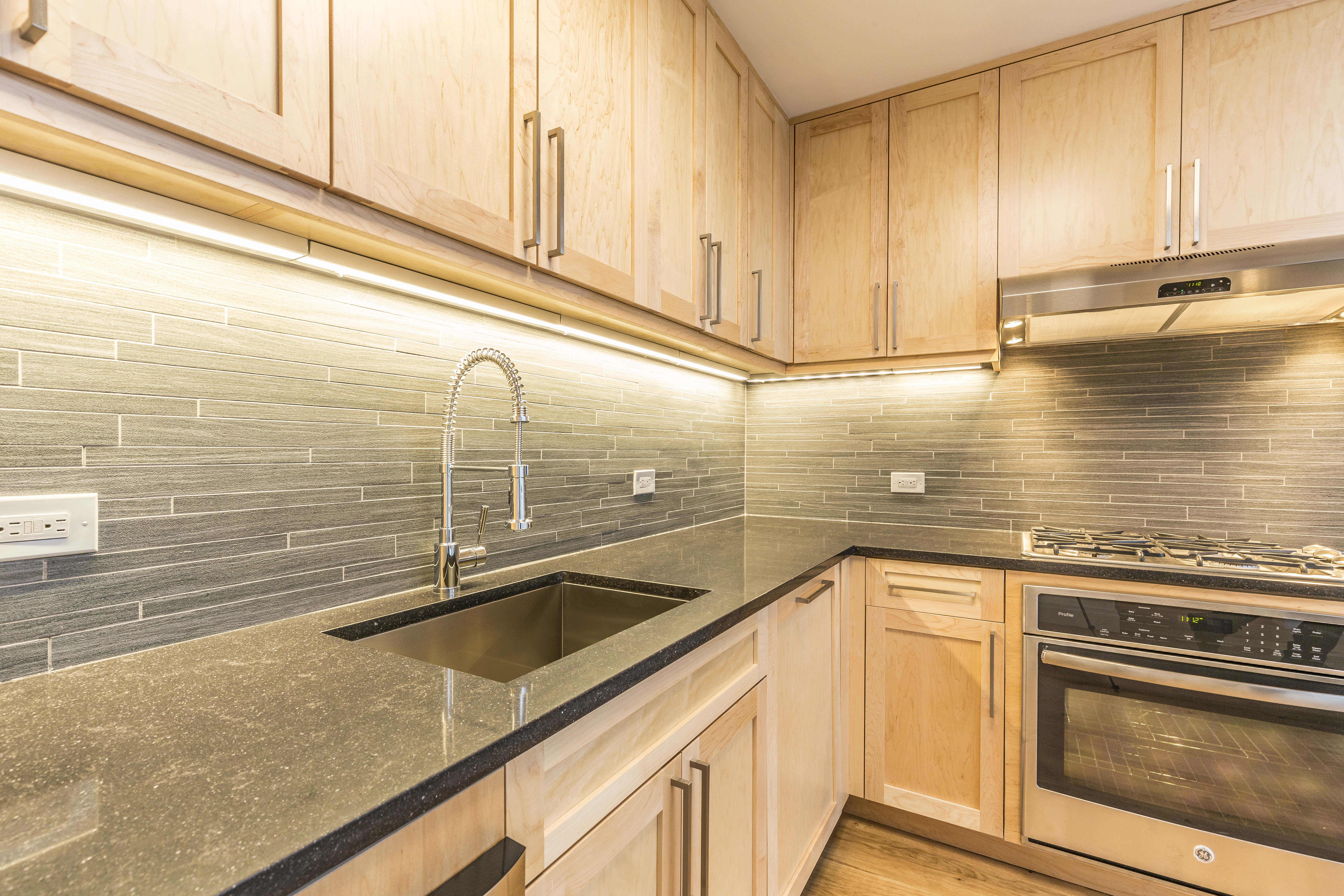 a view of a kitchen counter top a sink and cabinets