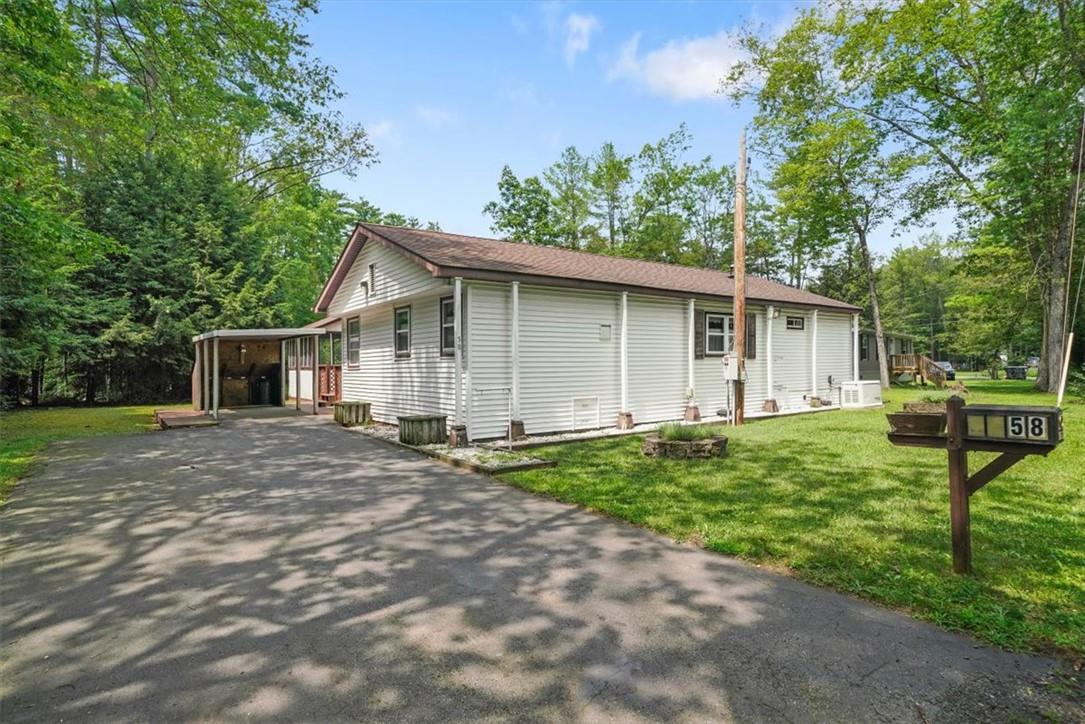 View of front of home featuring a front yard and a carport