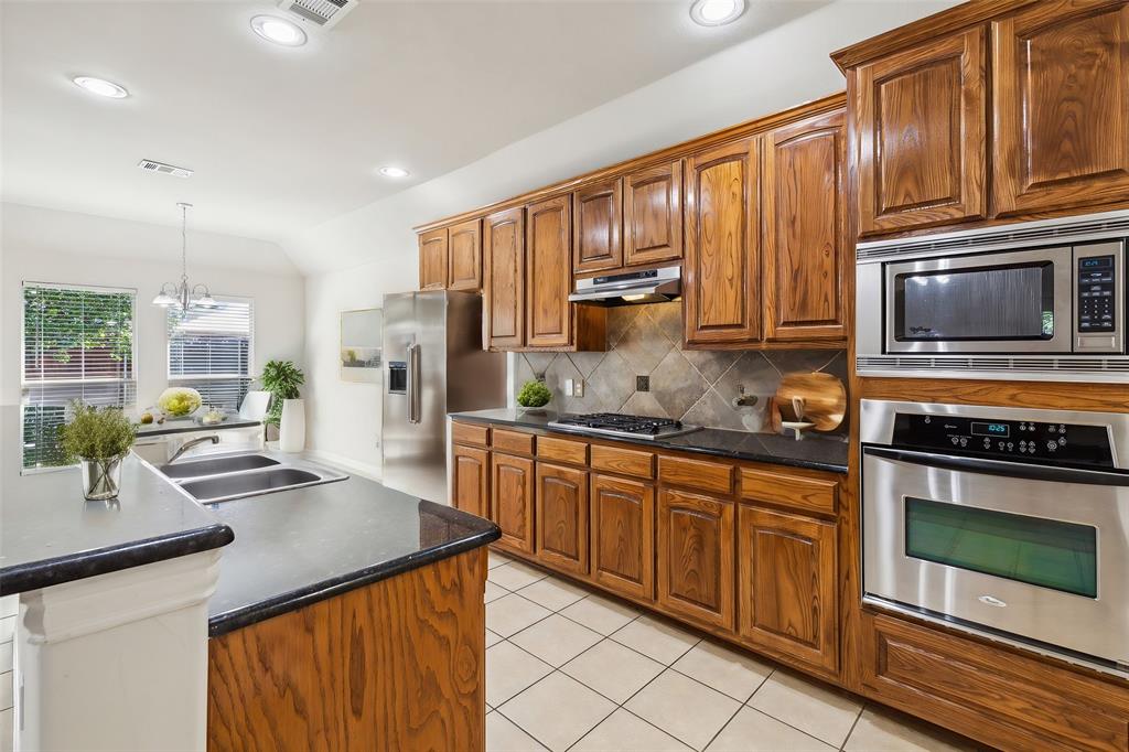 a kitchen with stainless steel appliances granite countertop a stove sink and cabinets