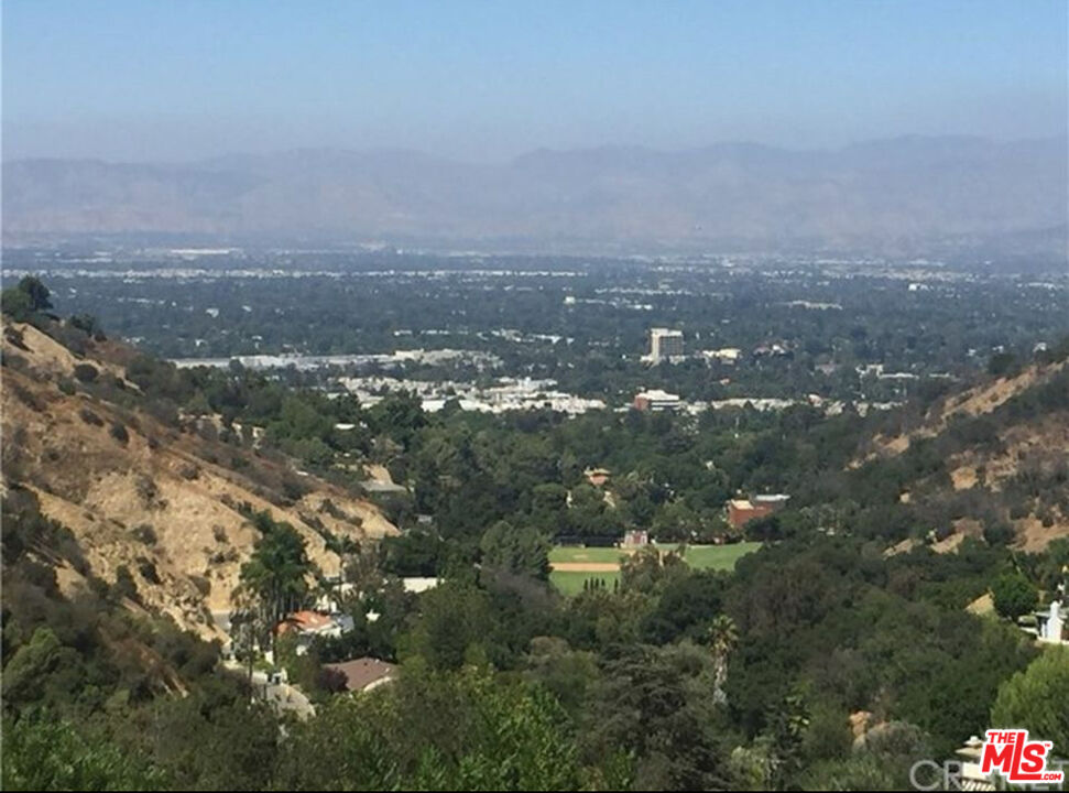 an aerial view of house with yard and mountain view in back