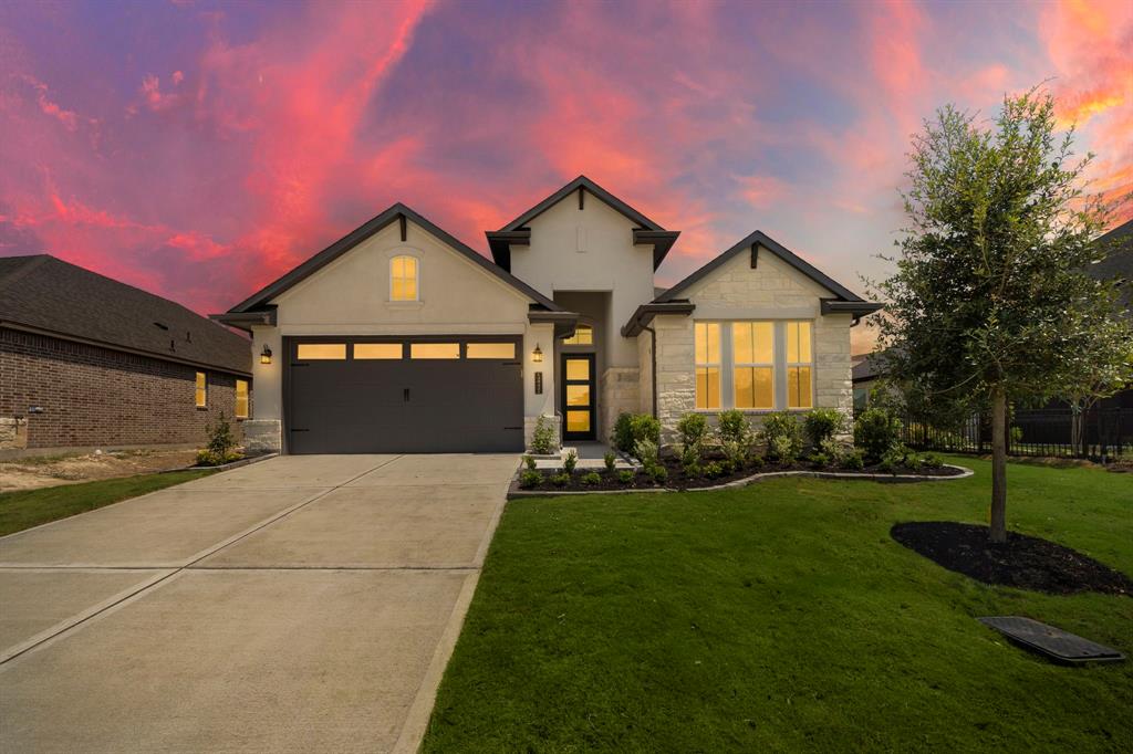 a front view of a house with a yard and garage