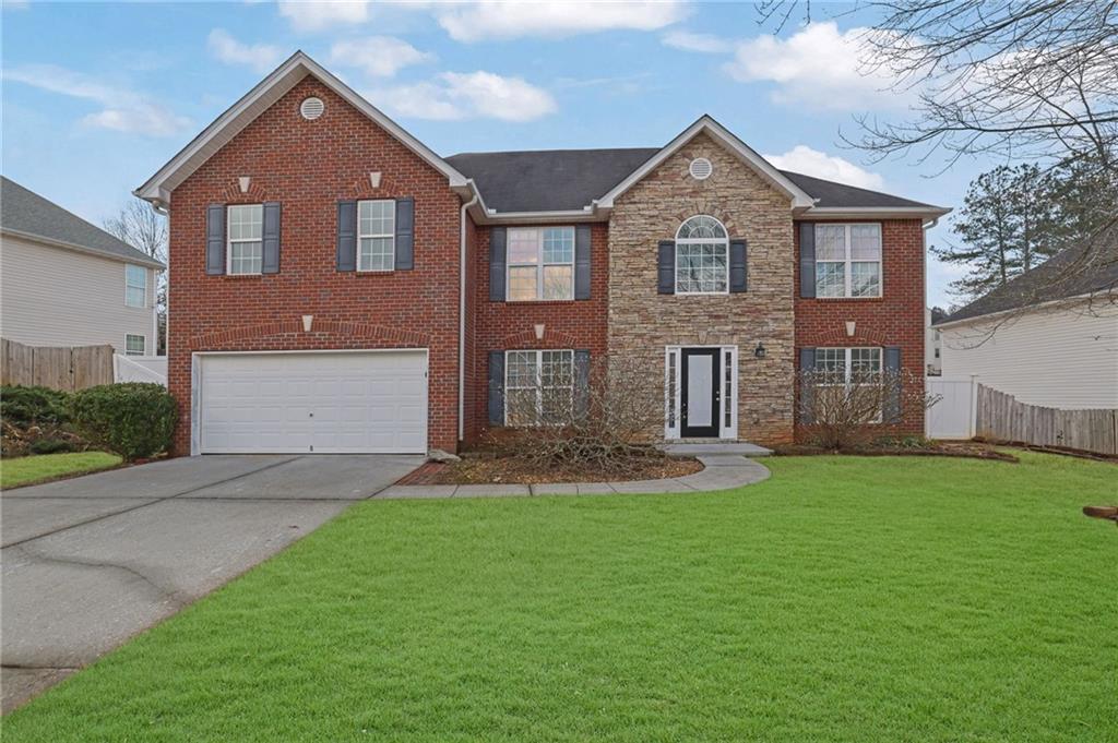 a front view of a house with a yard and garage