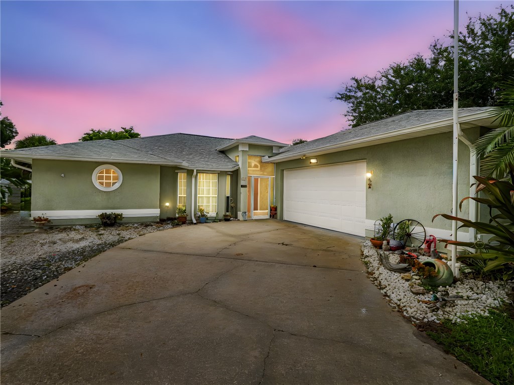 a view of a house with backyard space and a car parked in garage