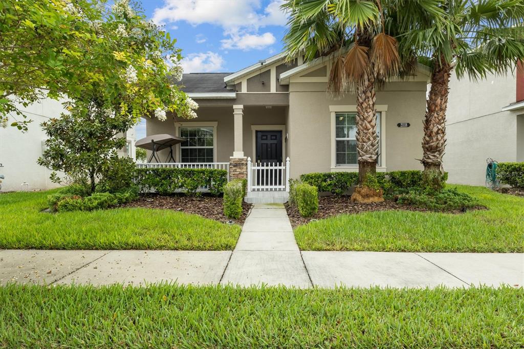 front view of a house with a yard and palm trees