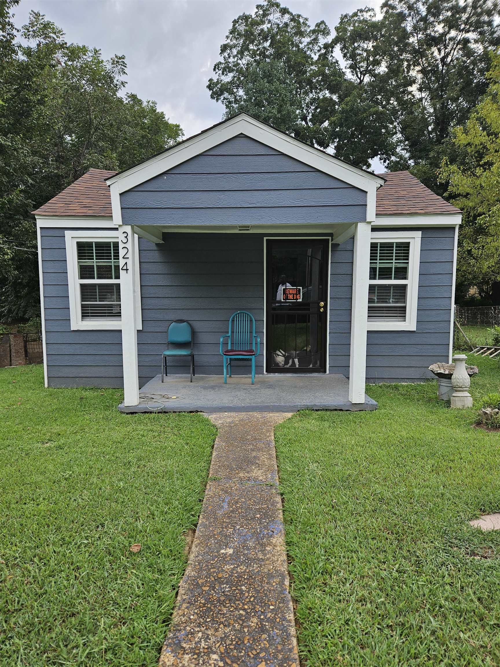 a front view of a house with a garden and plants