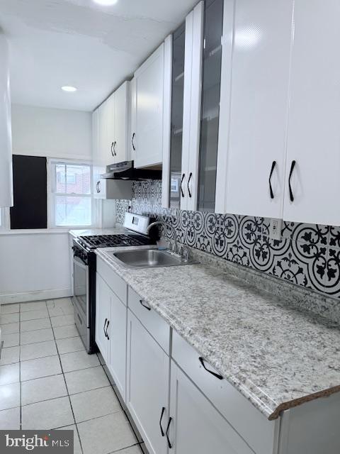 a kitchen with a sink a stove and cabinets