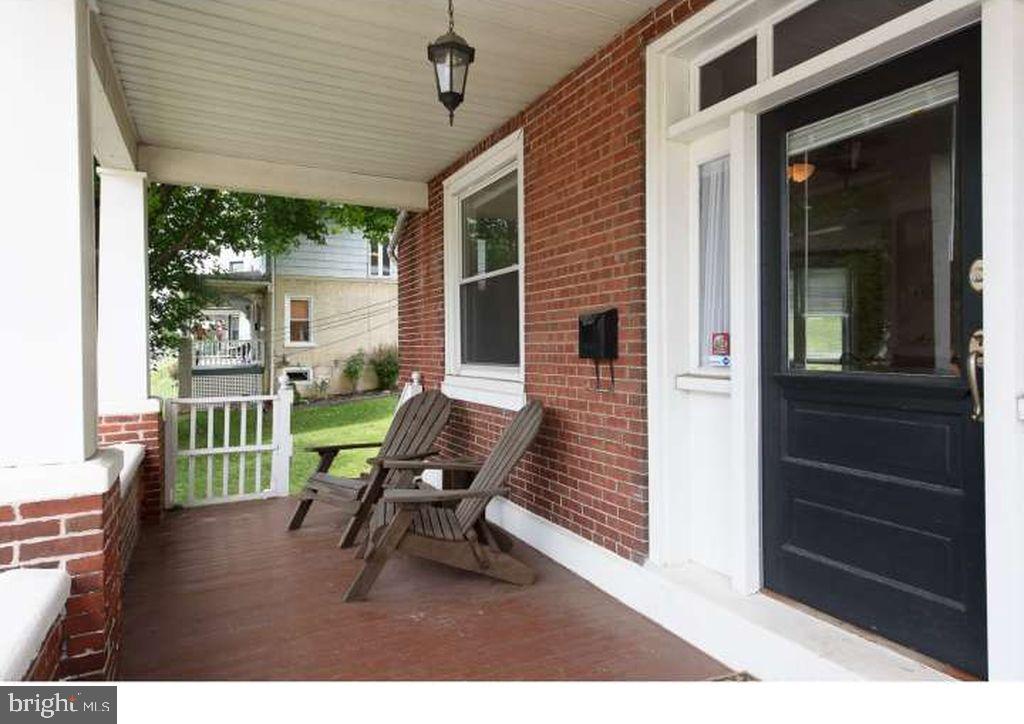 a porch with a bench next to a large window