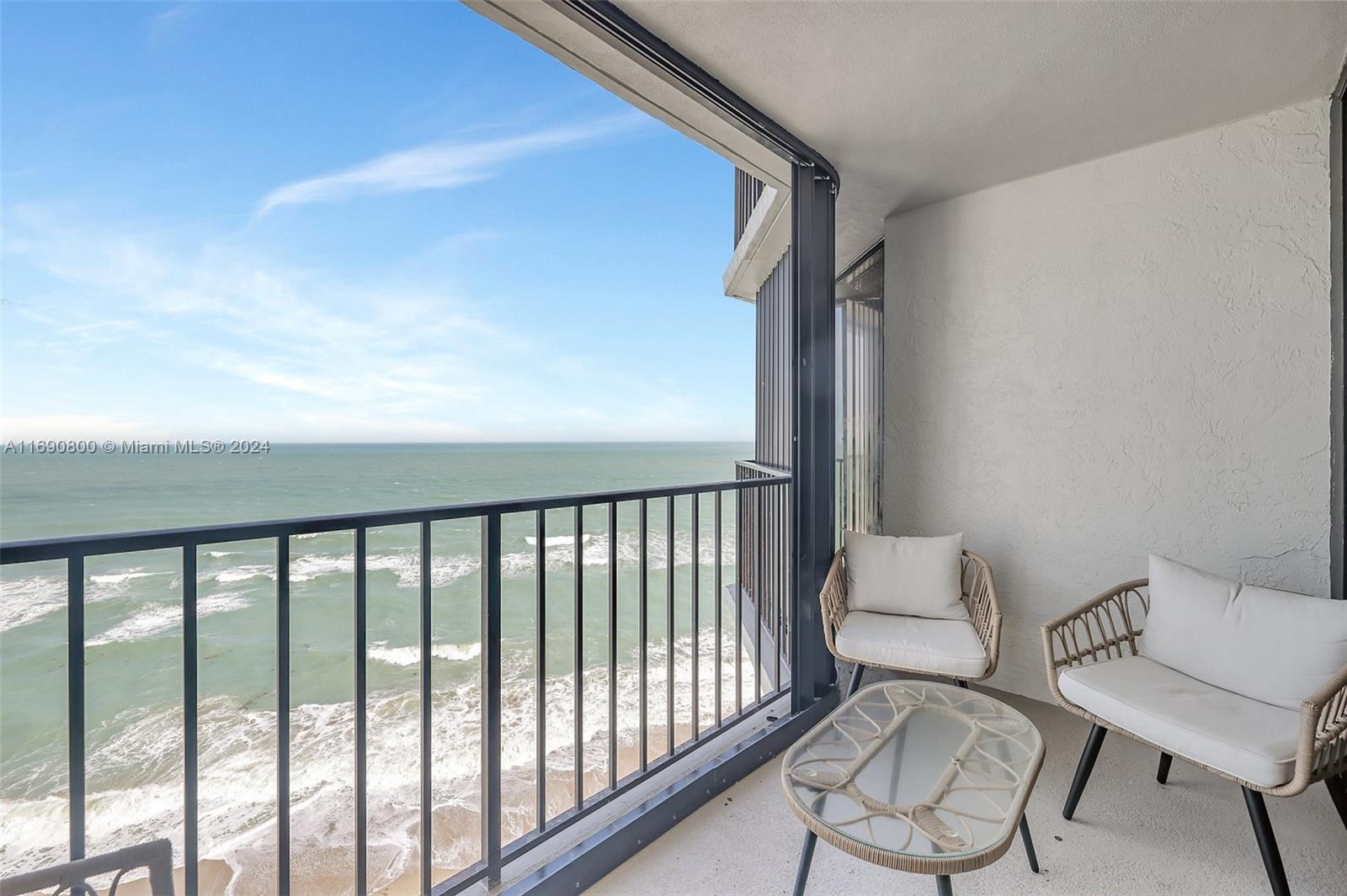 a balcony with chairs and table