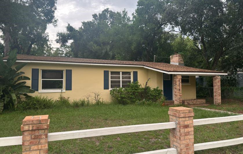 a front view of a house with a yard and garden