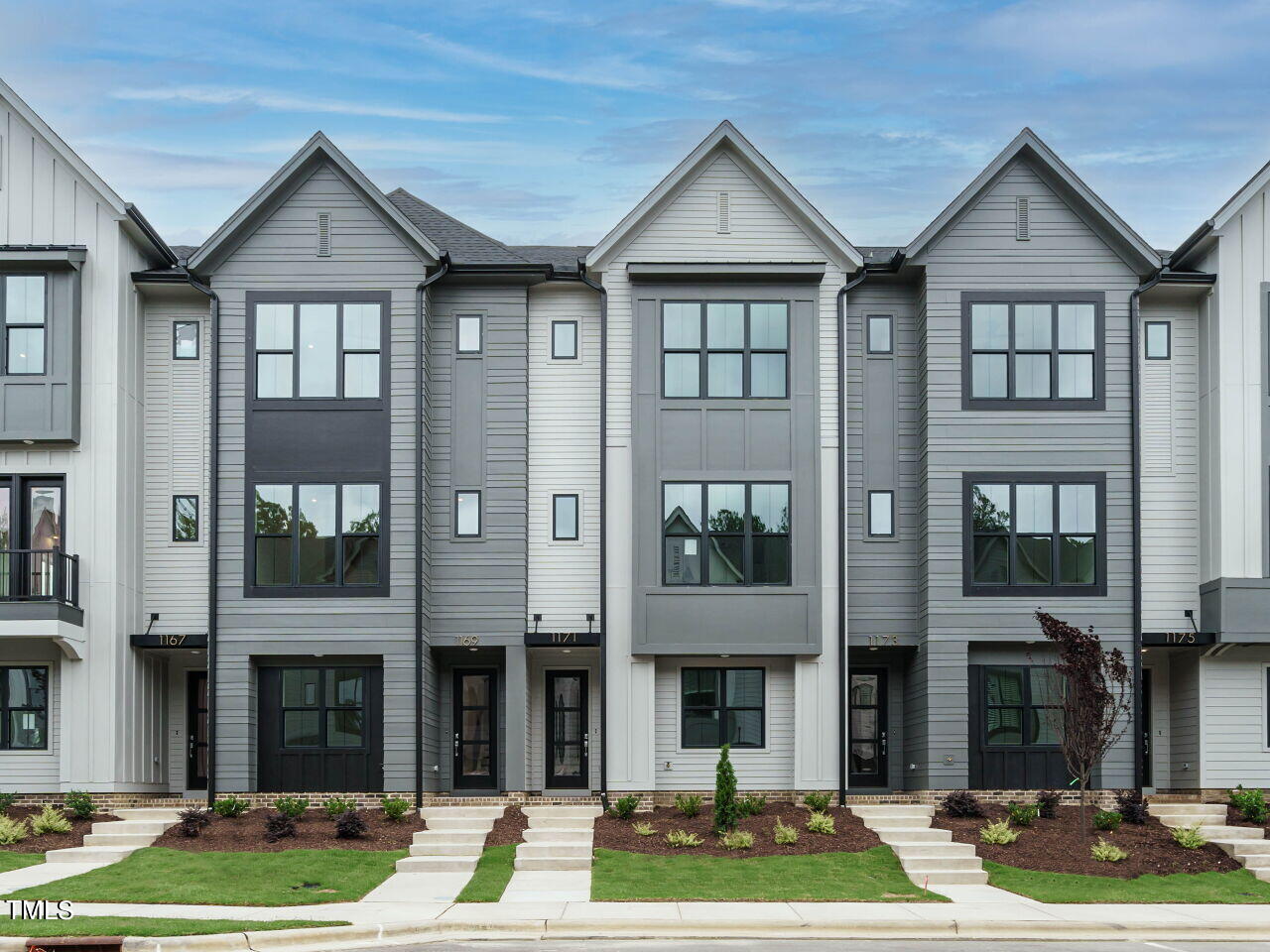 a front view of a residential apartment building with a yard