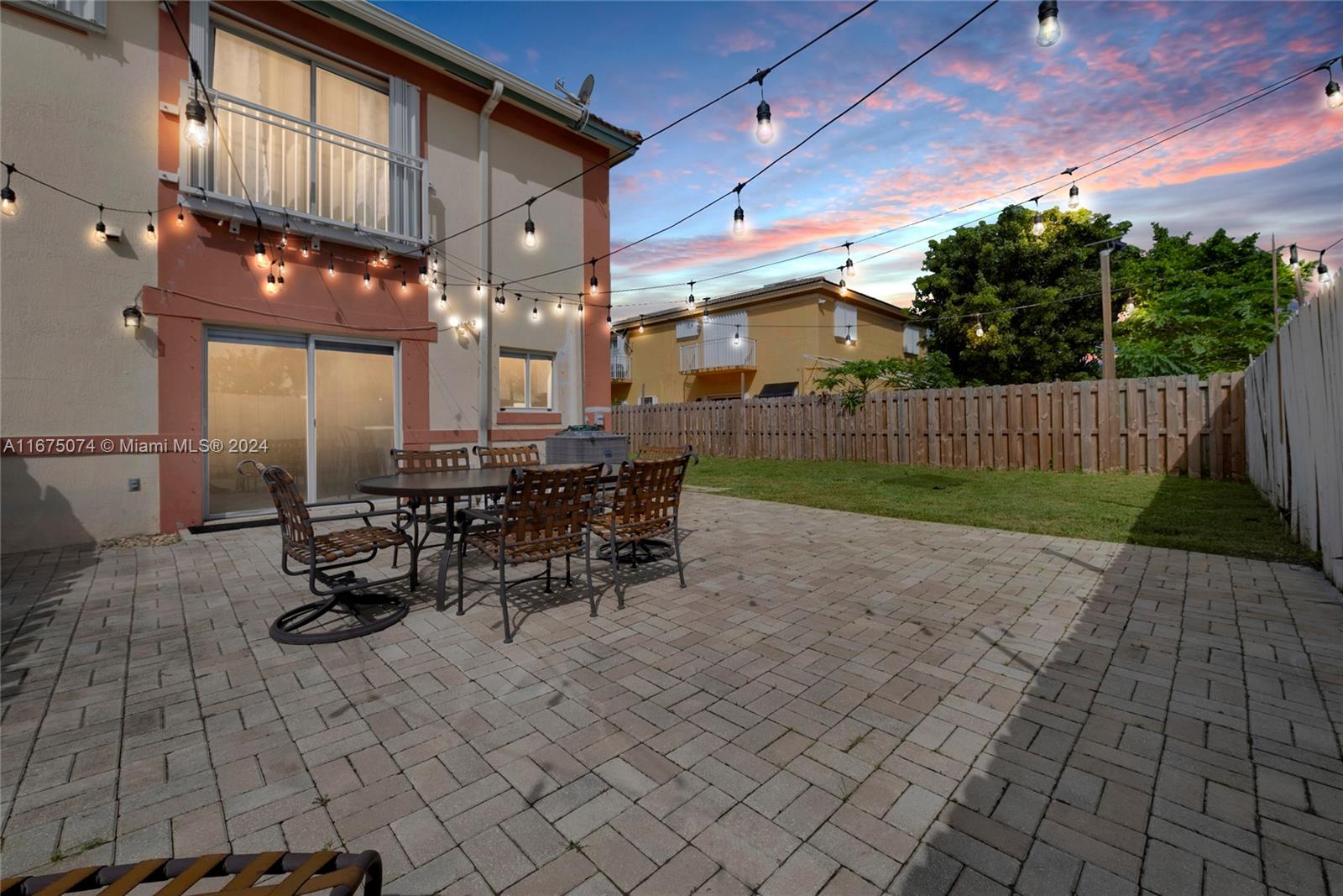 a view of a patio with table and chairs with wooden fence