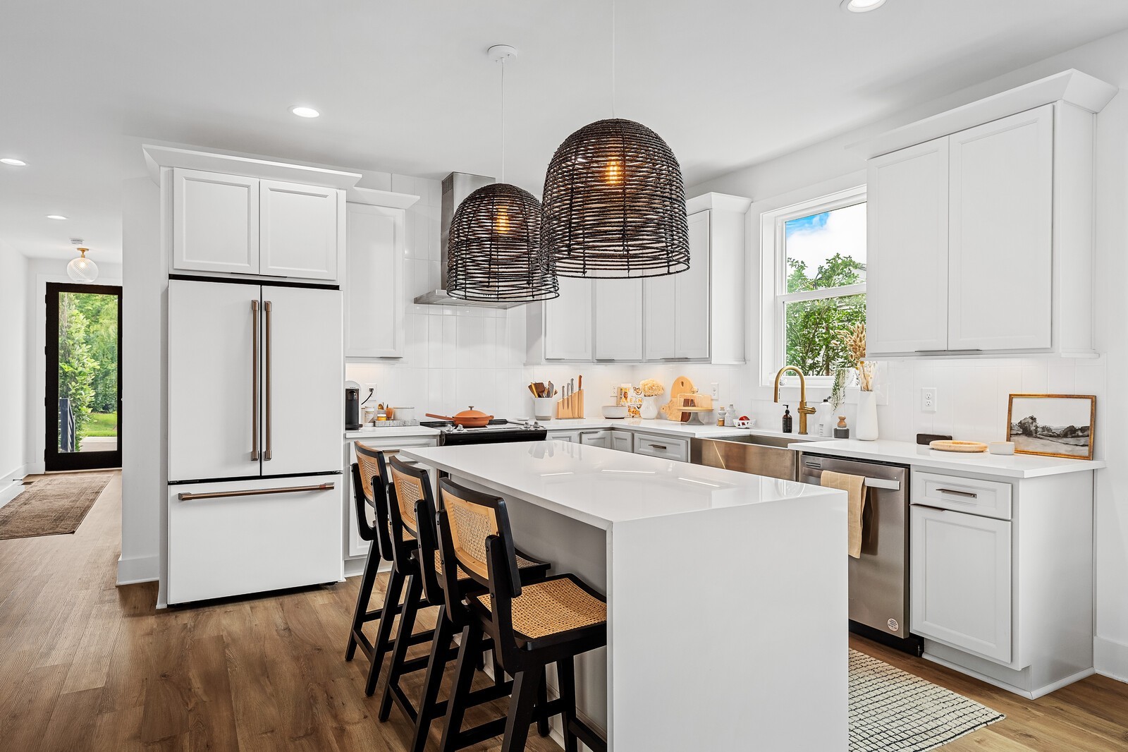 a kitchen with stainless steel appliances a dining table chairs refrigerator and sink