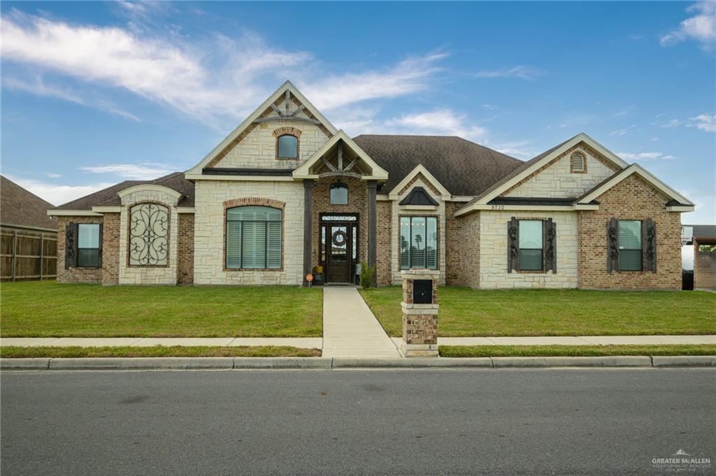 a front view of a house with a garden and yard