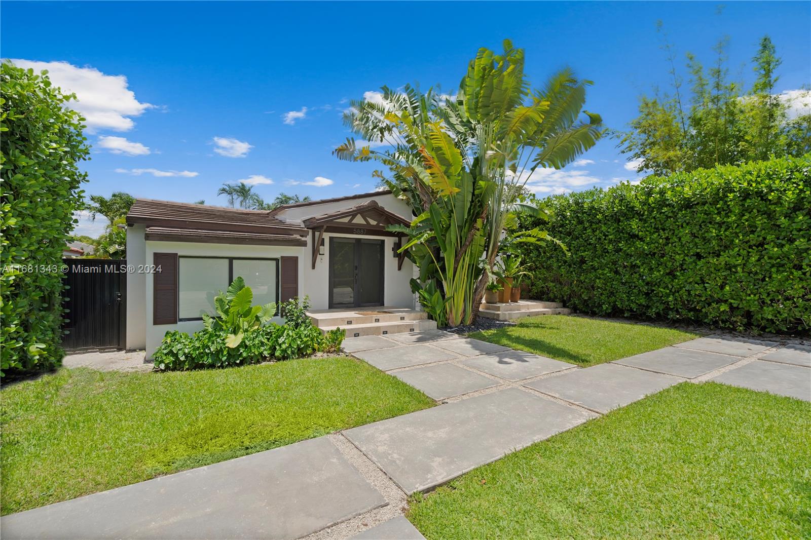 a front view of a house with a garden