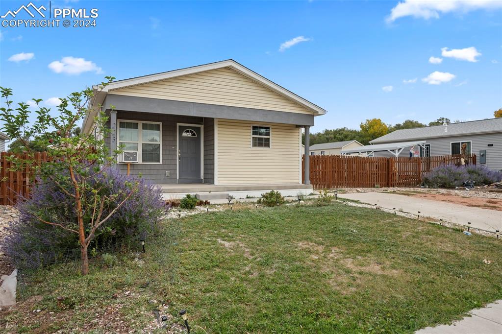 Bungalow-style house featuring a front yard and cooling unit