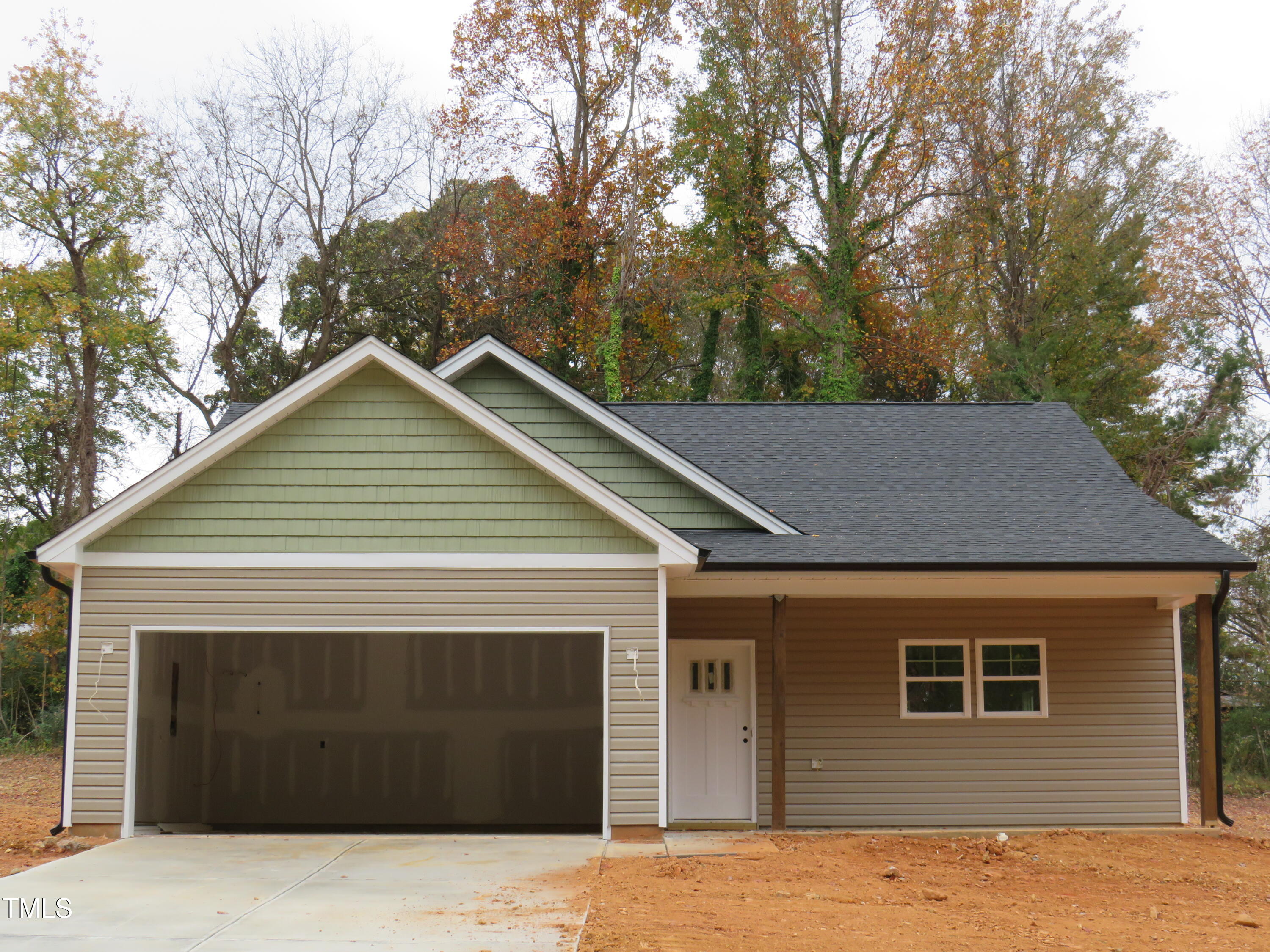 a front view of a house with yard and trees