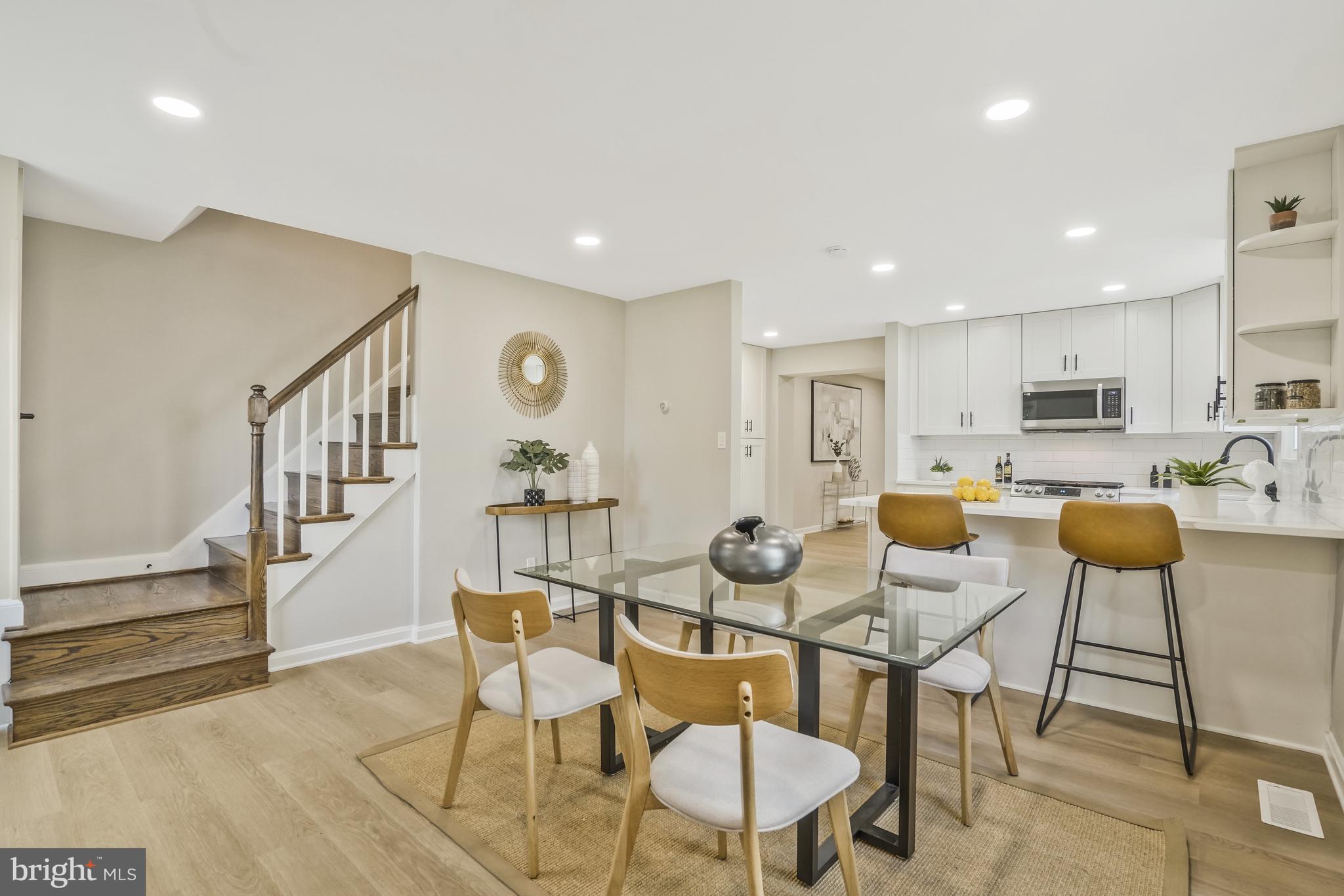 a living room with furniture kitchen view and a wooden floor