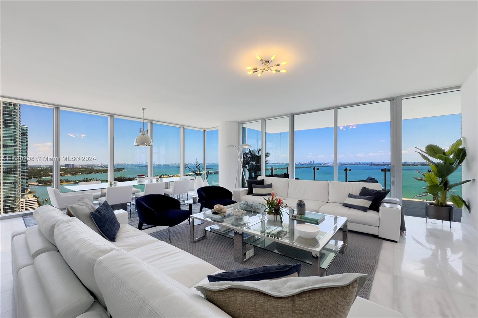 a living room with furniture kitchen view and large windows