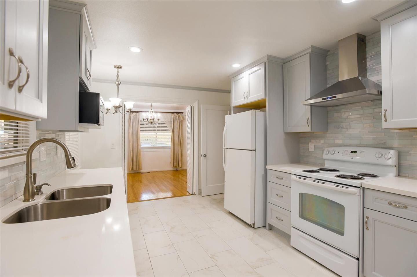 a kitchen with stainless steel appliances granite countertop a stove a sink and a refrigerator