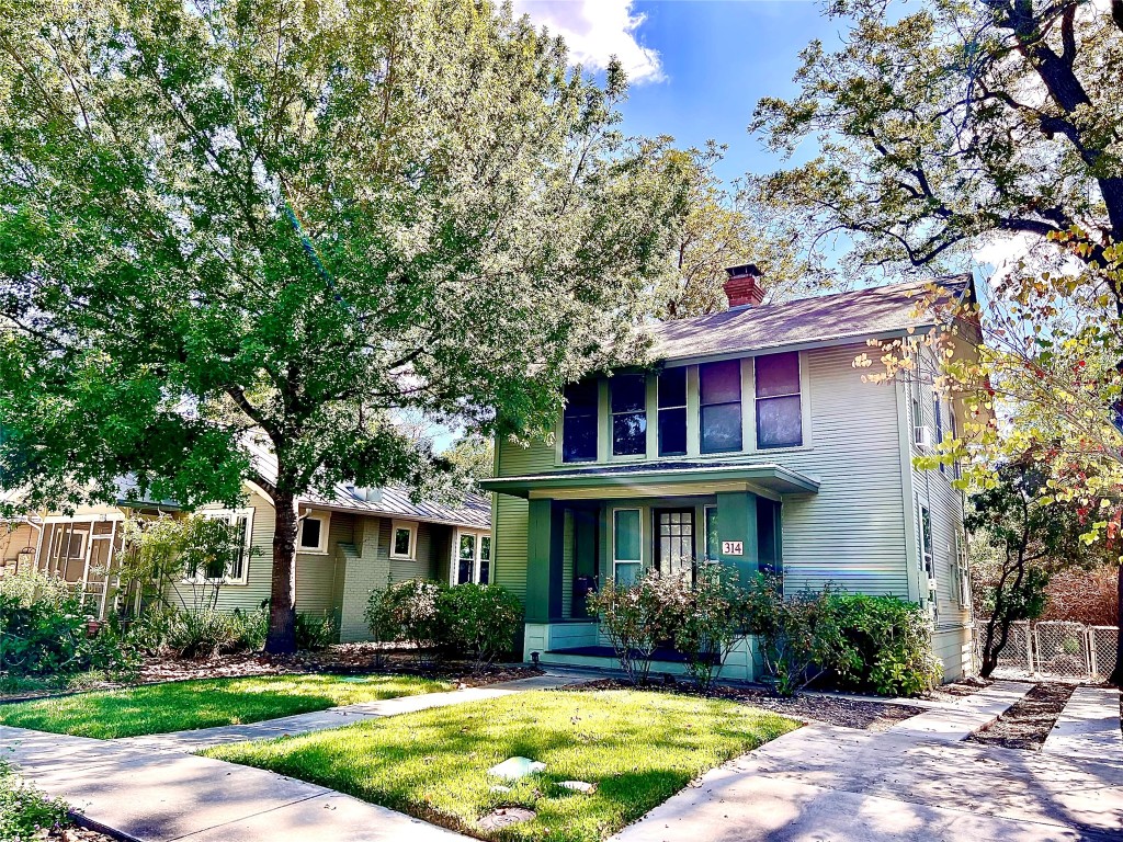 a front view of a house with a yard and trees