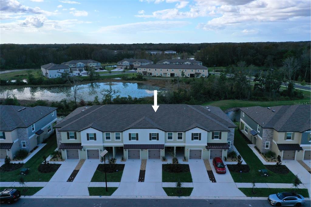 an aerial view of multiple houses with a yard