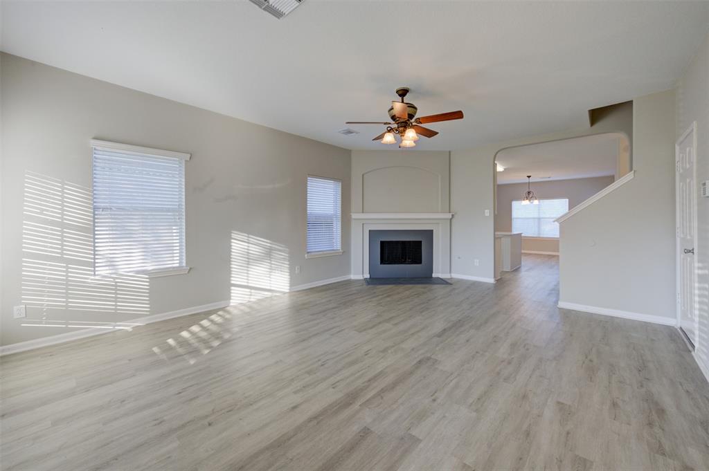 a view of empty room with wooden floor and fireplace