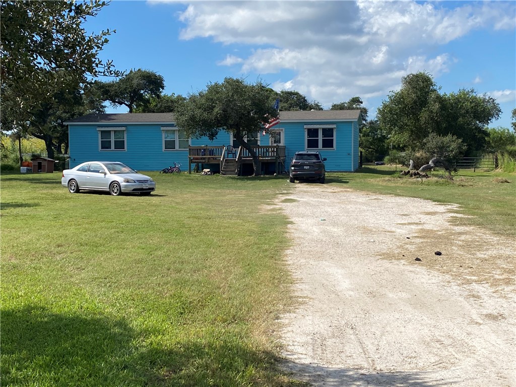 a view of a house with backyard and a tree